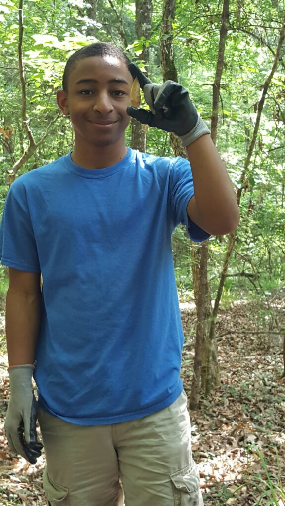 A boy wearing blue shirt holding a stone