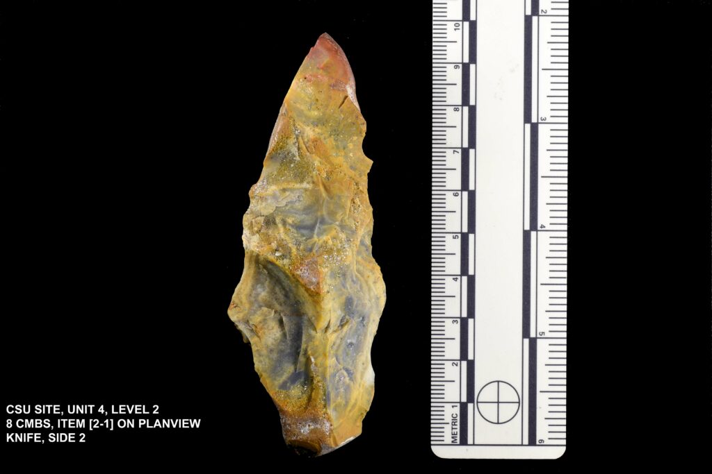 Photo of a ruler and a yellow stone