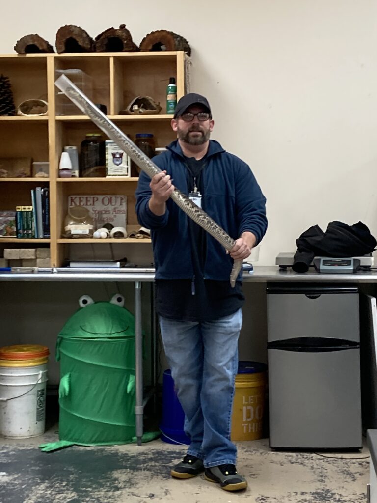 Man on blue holding snake